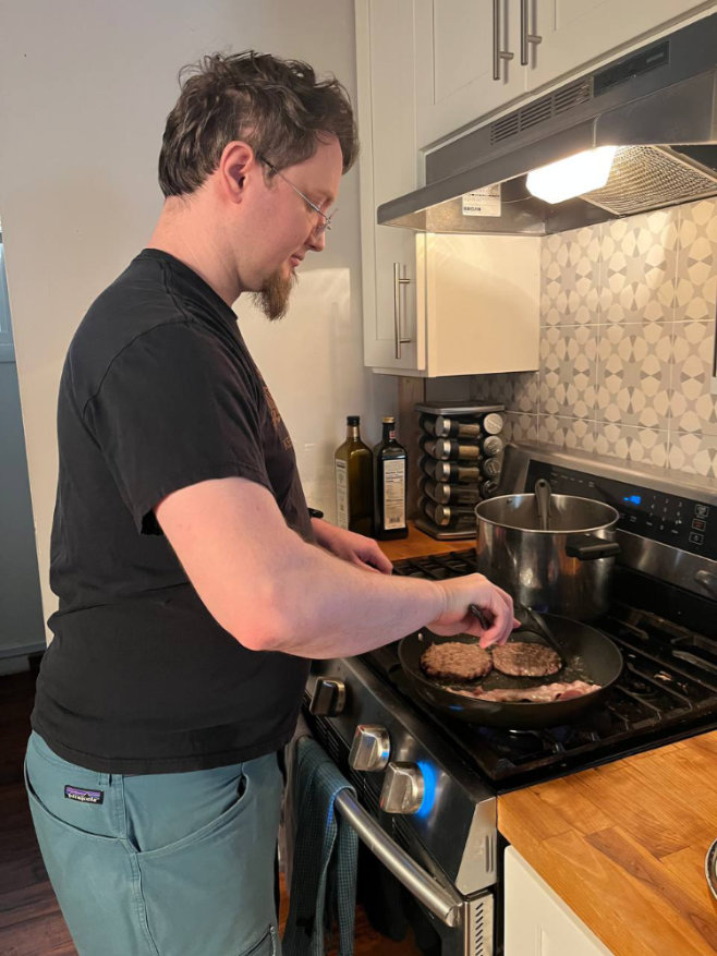 James cooking burgers on the stove